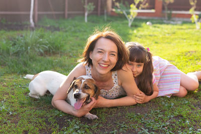 Portrait of girl with dog on grass
