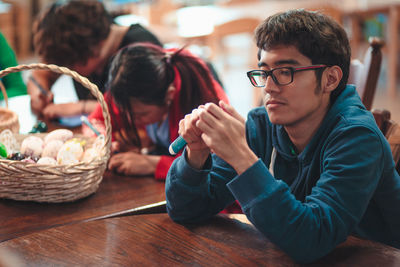 Family making easter eggs on table at home