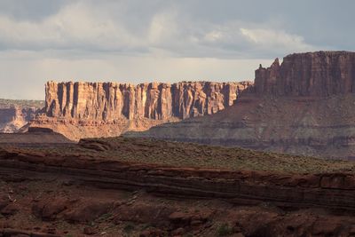 Scenic view of rock formations against cloudy sky