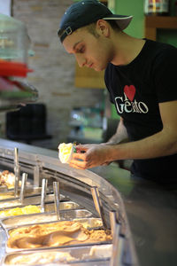 Side view of man preparing food