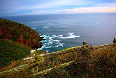 Scenic view of sea and mountains against sky