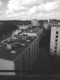 High angle view of buildings by river against sky