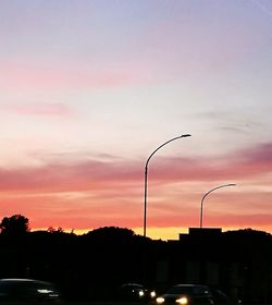 Silhouette street against sky at sunset