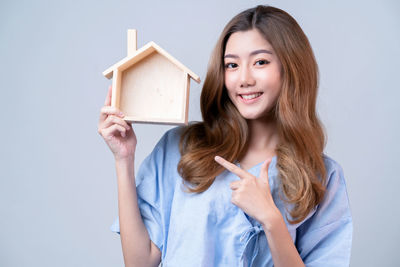 Portrait of young woman smiling against white background