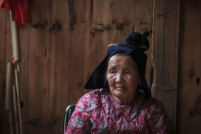 Portrait of woman standing against wall