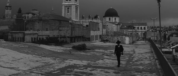 People walking on footpath by church in city