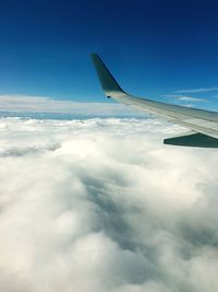 Cropped image of airplane flying over cloudscape