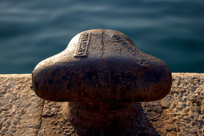 Close-up of old rusty metal by sea