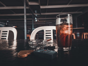 Close-up of drink on table with a cigarette and car keys