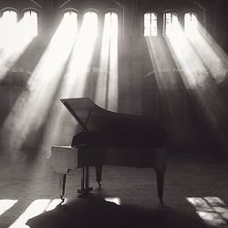 Sunlight streaming through windows on grand piano