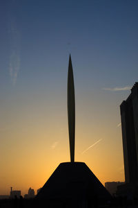 Low angle view of silhouette buildings against sky at sunset