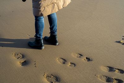 Low section of man standing at beach