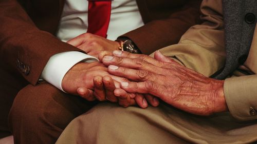 Midsection of couple holding hands