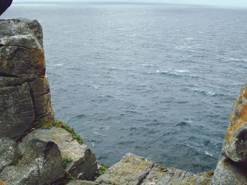 High angle view of rock formation in sea against sky