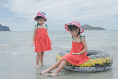 Cute girls at beach against sky