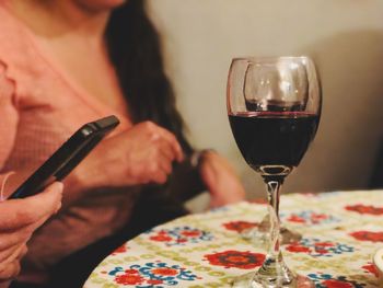 Midsection of woman holding wineglass