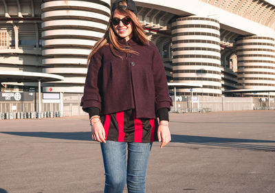 Portrait of young woman wearing sunglasses standing outdoors