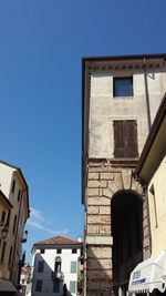 Low angle view of houses against clear blue sky