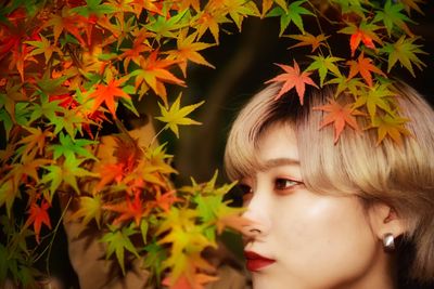 Close-up portrait of girl with autumn leaves