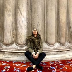 Young woman sitting on wall