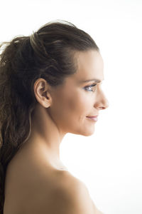 Close-up portrait of a smiling young woman over white background