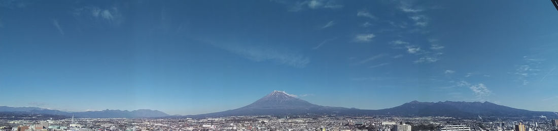 Scenic view of mountains against blue sky