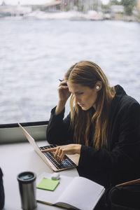 Businesswoman pointing at laptop while sitting in ferry