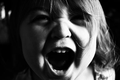 Close-up portrait of cute girl screaming