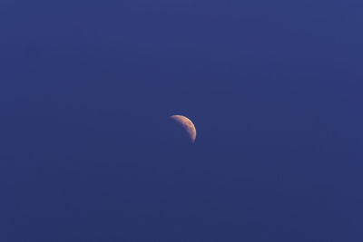 Low angle view of moon against blue sky