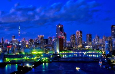 Illuminated buildings in city against sky at night