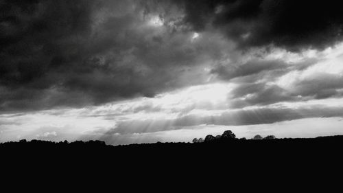 Silhouette of landscape against cloudy sky