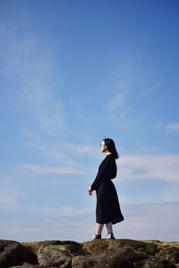 Full length of woman standing against sky