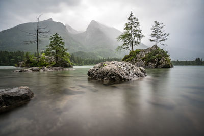 View of rocks in water against sky