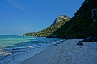 Scenic view of beach against clear blue sky