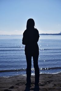 Rear view of silhouette man standing on beach