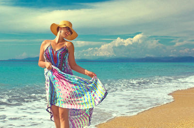 Portrait of smiling young woman standing on beach