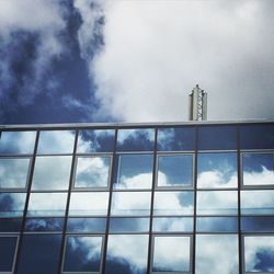 Low angle view of modern building against cloudy sky