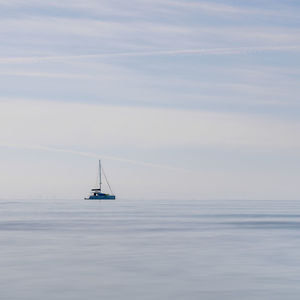 Sailboat sailing on sea against sky