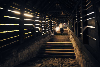 Man walking on illuminated corridor