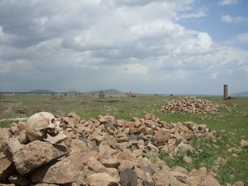 Rocks on field against sky