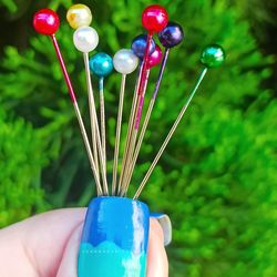 Close-up of hand holding multi colored balloons