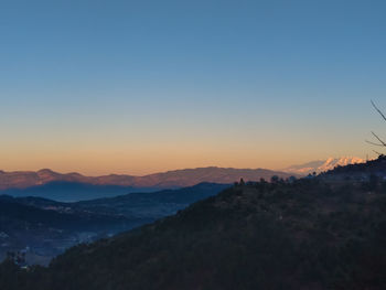 Scenic view of mountains against clear sky during sunset