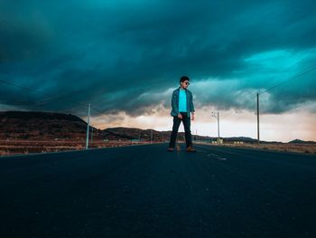 Man standing on road against sky