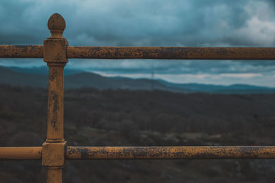 Close-up of rusty railing against sky
