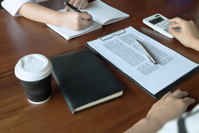 High angle view of man using smart phone on table