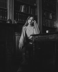 Portrait of young woman sitting by table