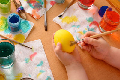 Cropped image of hands painting egg during easter