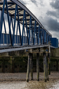 Low angle view of bridge over river against sky