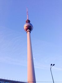 Low angle view of communications tower against blue sky