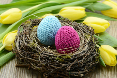 Close-up of easter eggs and yellow tulips on table